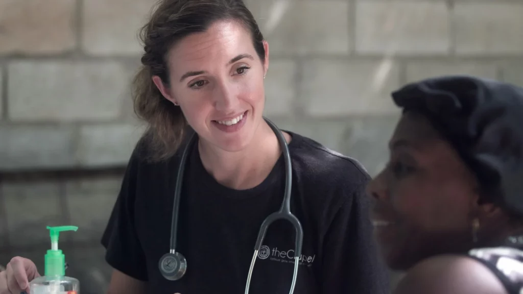 a woman in scrubs explaining her friend what training is required to be a travel nurse
