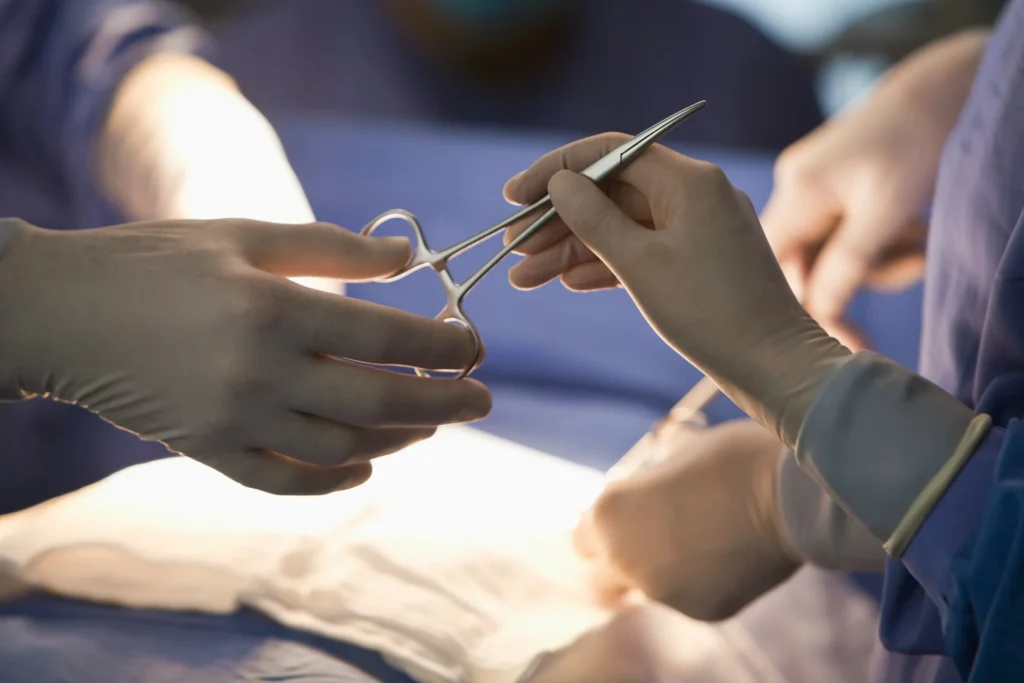 photo - cvor travel nurse passing scissors to the surgeon in or