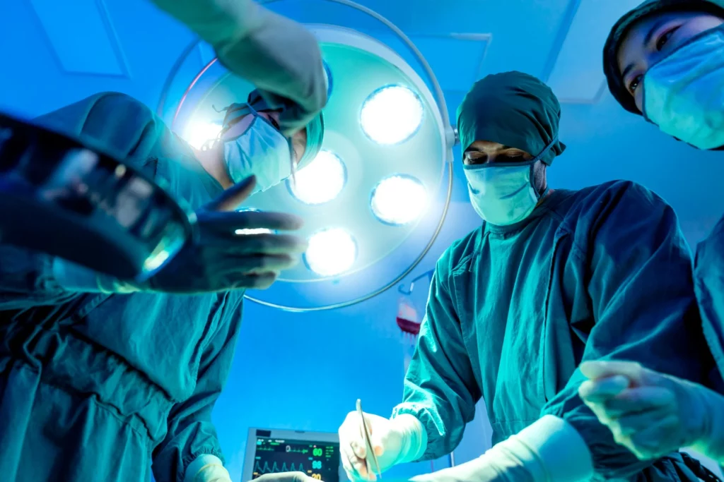photo - doctor and or nurses looking down at the patient on the operating table