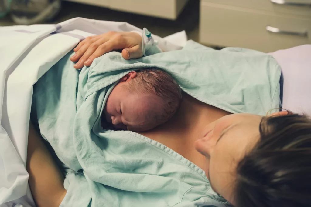 photo - a newborn lying on mother's chest right after delivery