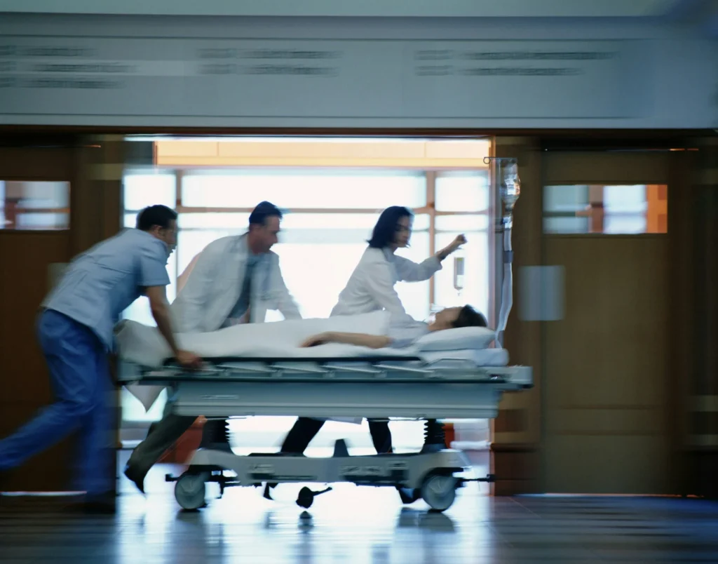 photo - a team of er nurses and techs rushing a client to the icu