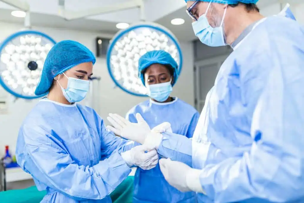 photo - three medical staff prepping for a surgery in an OR