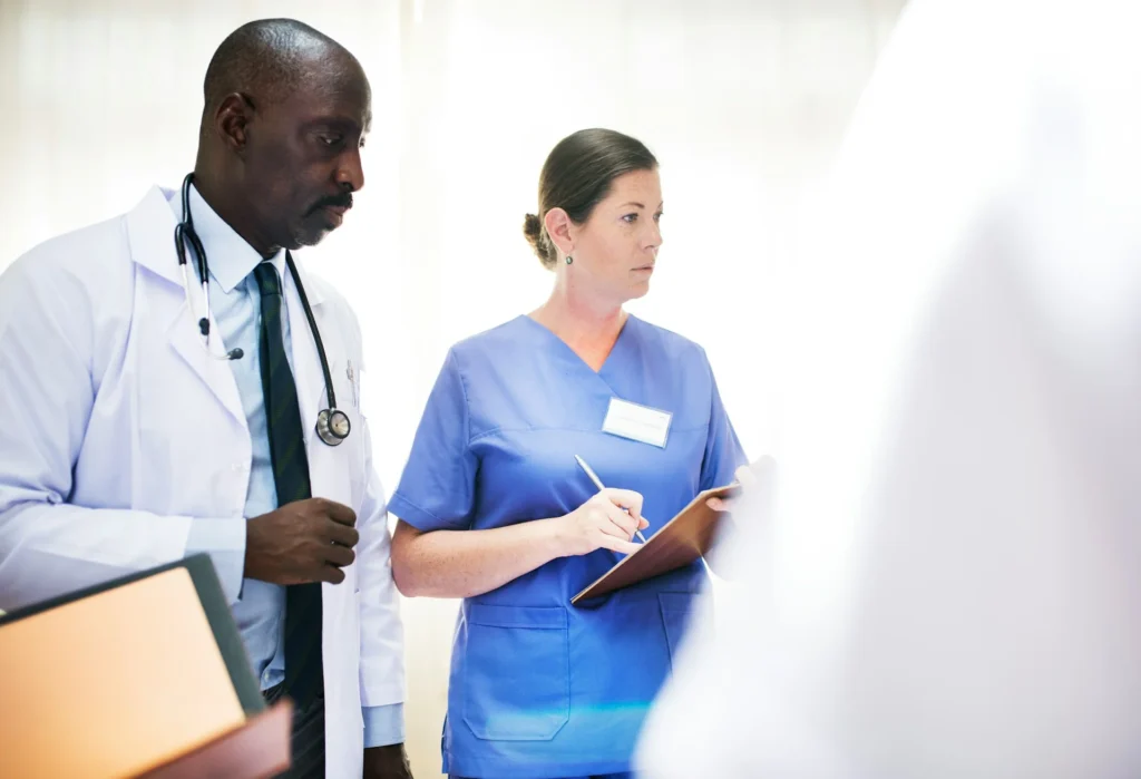 photo - a nurse and a doctor talking to a patient